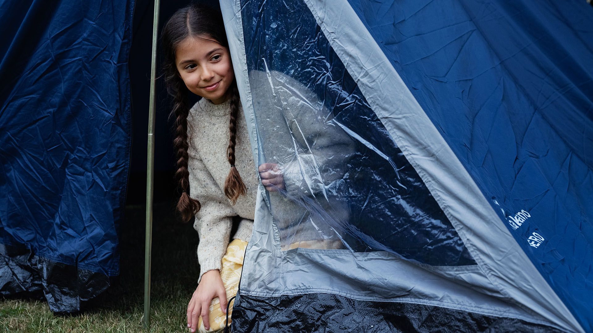 Pige i telt, hvor rejseforsikringen også dækker campingferie.